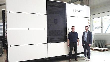 Franz-Josef Feilmeier und Thomas G&ouml;&szlig;wein (r.) vor einem Industriestromspeicher im Werk in Iggensbach.