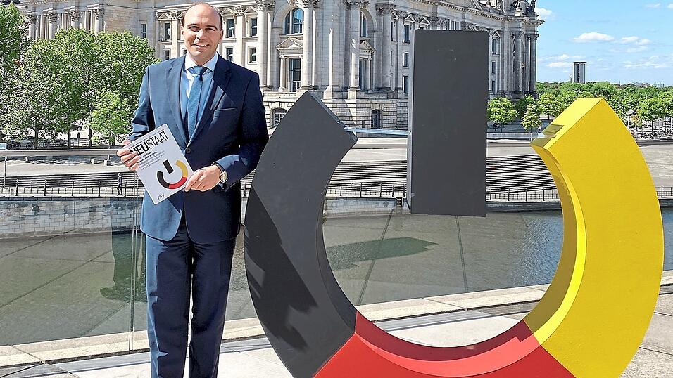 Florian Oßner mit einem schwarz-rot-goldenen Computer-Einschaltknopf als Symbol für einen Neustart im Staatswesen. Florian Oßner mit einem schwarz-rot-goldenen Computer-Einschaltknopf als Symbol für einen Neustart im Staatswesen.