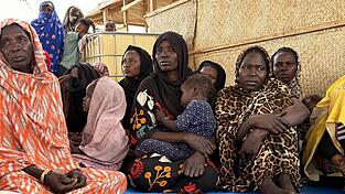 Fl&uuml;chtlinge aus dem Sudan warten in der tschadischen Grenzstadt Adr&eacute; auf dem Gel&auml;nde des Roten Kreuzes auf den Weitertransport in ein Fl&uuml;chtlingslager. Hinter einigen von ihnen liegt eine monatelange Odyssee durch die Kampfgebiete im Sudan.