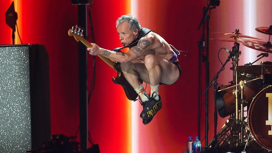 Flea von den Red Hot Chili Peppers macht Luftsprünge.