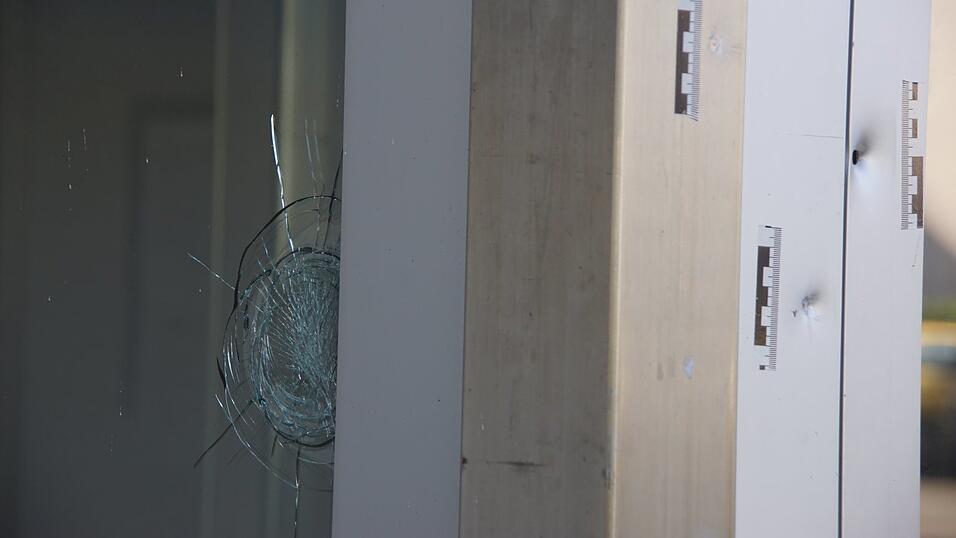 Einschusslöcher in und neben einer Eingangstüre in Neutraubling. Sie befinden sich auf Brust- beziehungsweise Kopfhöhe.