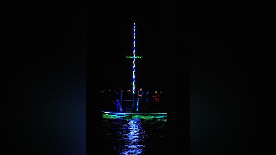 Bunt beleuchtete Boote fahren bei der Lampionfahrt über die Donau.