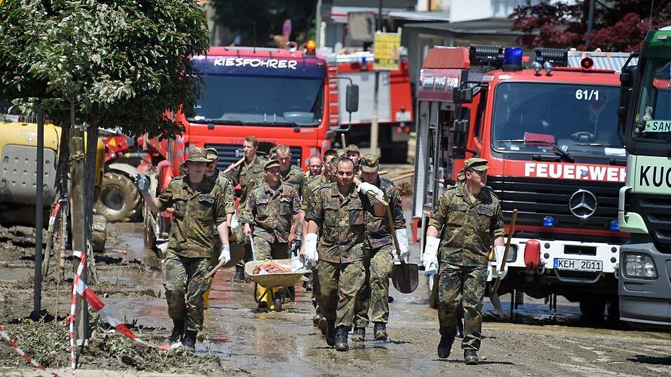Soldaten des Panzerpionierbataillon 4 gehen am 6. Juni 2016 in Simbach durch ein Wohngebiet, um sich an den Aufr&auml;umarbeiten zu beteiligen.