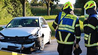 Die Feuerwehr hilft dem Abschleppdienst, den schwer besch&auml;digten Golf von der Stra&szlig;e zu schaffen.