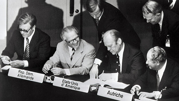 Alle sitzen an einem Tisch: Mit der Unterzeichnung der Schlussakte durch die politischen F&uuml;hrer von 35 Staaten Europas und Nordamerikas ging 1975 in Helsinki die Konferenz &uuml;ber Sicherheit und Zusammenarbeit in Europa (KSZE) zu Ende. Im Bild (v. l.): Bundeskanzler Helmut Schmidt, Erich Honecker, Erster Sekret&auml;r der SED, US-Pr&auml;sident Gerald Ford und der &ouml;sterreichische Bundeskanzler Bruno Kreisky. F&uuml;r die Sowjetunion nahm der Staats- und Parteichef Leonid Breschnew an der Konferenz teil.