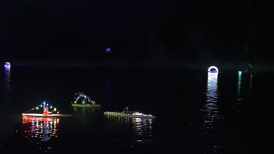 Bunt beleuchtete Boote fahren bei der Lampionfahrt über die Donau.