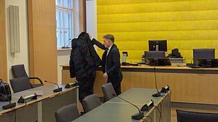 Mit einer schwarzen Jacke verdeckt Strafverteidiger Maximilian Pauls die Sicht auf seinen Mandanten. Um dem Opfer und ihrer Mutter die Aussagen zu ersparen, wurde ein umfassendes Gest&auml;ndnis versprochen.