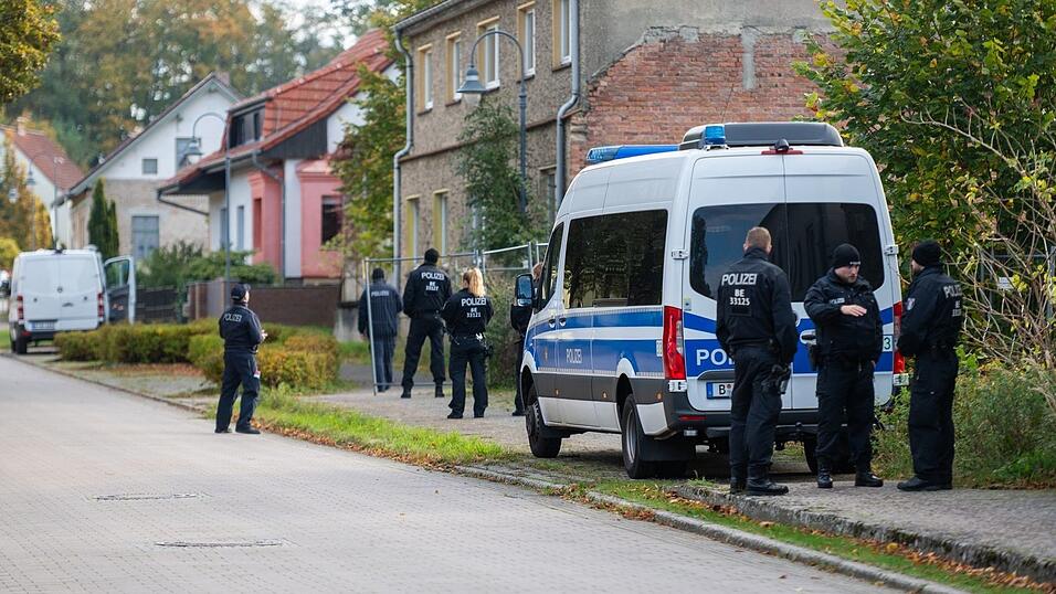 Polizisten stehen vor einem Grundstück in Herzberg.