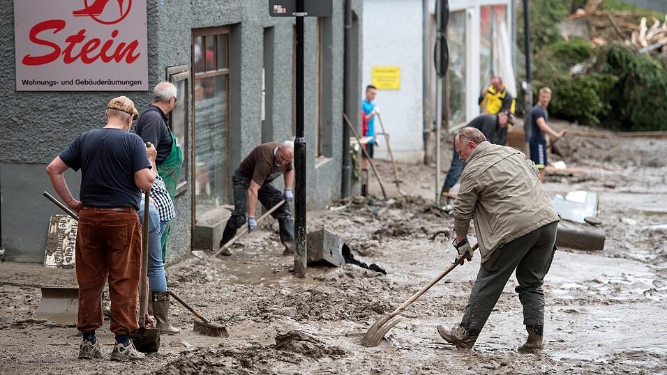 Anwohner beseitigen am 2. Juni 2016 den Schlamm von den Stra&szlig;en.