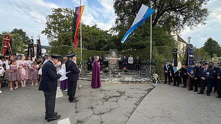 Diakon Harald Schneider mit dem Jubelverein und den zahlreichen Festg&auml;sten beim Totengedenken am Kriegerdenkmal.