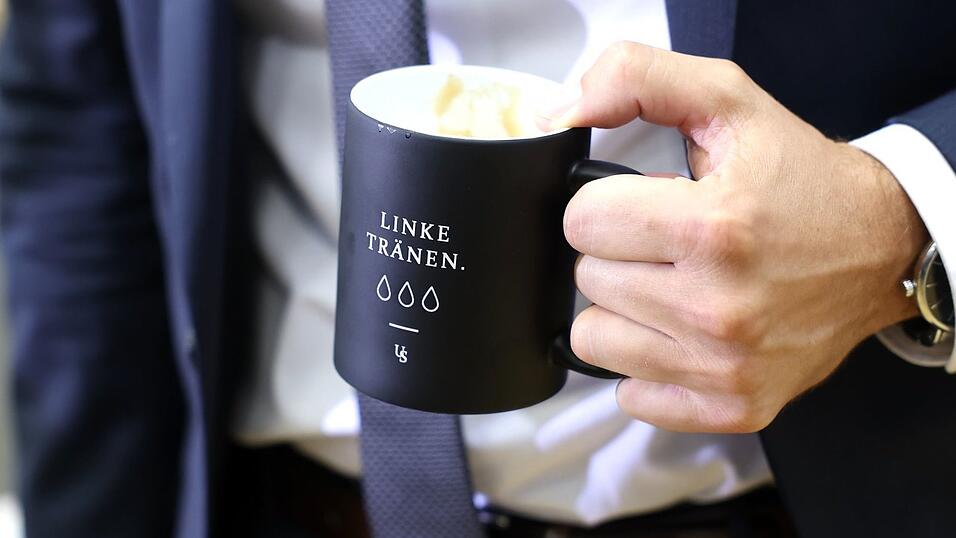 «Linke Tränen» steht auf einer Tasse, mit der Ulrich Siegmund (AfD) zur konstituierenden Sitzung des Landtags von Sachsen-Anhalt kommt. «Linke Tränen» steht auf einer Tasse, mit der Ulrich Siegmund (AfD) zur konstituierenden Sitzung des Landtags von Sachsen-Anhalt kommt.