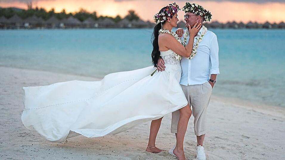 Romantischer Moment am Meer: Die frisch verm&auml;hlten Arthur und Erika Loibl genie&szlig;en blumenbekr&auml;nzt den Sonnenuntergang am Strand.