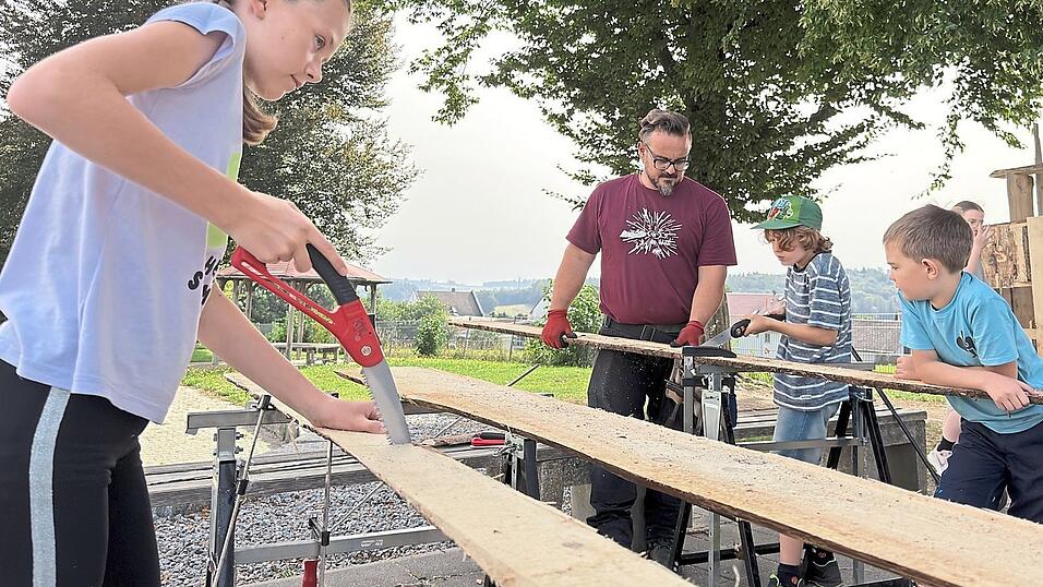 Mit ernsten Mienen s&auml;gen die Kinder, unterst&uuml;tzt von erwachsenen Helfern.