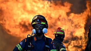 Ein Feuerwehrmann steht vor den lodernden Flammen nordwestlich von Athen. Ein Feuerwehrmann steht vor den lodernden Flammen nordwestlich von Athen.