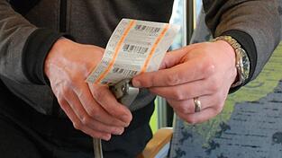 Die Hände eines Zugbegleiters bei der Fahrkartenkontrolle. Wer in der ersten Klasse sitzt, braucht auch ein Ticket für die erste Klasse.