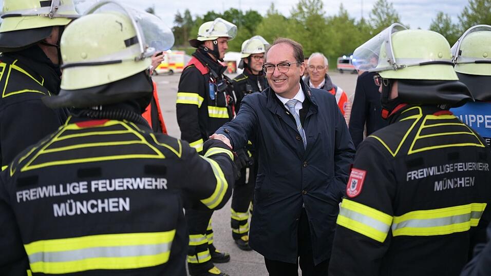 Sie bekommen f&uuml;r die &Uuml;bung frei: Rettungskr&auml;fte der Freiwilligen Feuerwehr werden von Innenminister Dobrindt begr&uuml;&szlig;t.