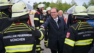 Sie bekommen f&uuml;r die &Uuml;bung frei: Rettungskr&auml;fte der Freiwilligen Feuerwehr werden von Innenminister Dobrindt begr&uuml;&szlig;t.