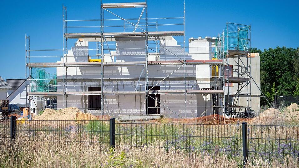 Ein Bauger&uuml;st steht an der Fassade eines sich im Bau befindlichen Einfamilienhauses.
