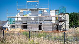 Ein Bauger&uuml;st steht an der Fassade eines sich im Bau befindlichen Einfamilienhauses.