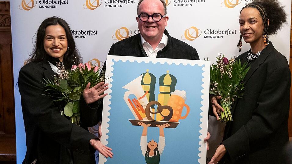 Wiesnchef Clemens Baumg&auml;rtner (M.) pr&auml;sentiert mit den K&uuml;nstlerinnen Amiera Harithas (l.) und Dinah-Charles Francis das offizielle Motiv zum Oktoberfest 2025.