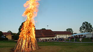 Die lodernden Flammen aus dem Holzturm, im Hintergrund das Partyzelt und und das Feuerwehrgerätehaus Die lodernden Flammen aus dem Holzturm, im Hintergrund das Partyzelt und und das Feuerwehrgerätehaus