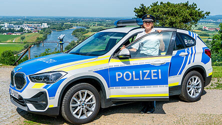 Daniela Neumayer, Leiterin der Polizeidienststelle in Bogen, steht mit einem Polizeiauto auf dem Bogenberg. Nach 37 Dienstjahren h&ouml;rt sie auf, sie freut sich auf die kommende freie Zeit.