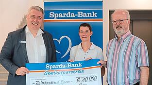 Manfred Decker (links), Filialleiter der Sparda-Bank in Cham, &uuml;berreicht den Spendenscheck an Sarah Hutterer und Pater Jens Bartsch f&uuml;r die Chamer Tafel.