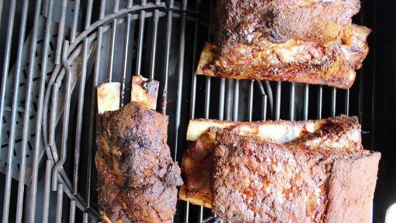 Die geräucherten Beef Ribs auf dem Rost vom Gasgrill. Links erkennt man unter dem Rost die dort platzierte Räucherbox. Die geräucherten Beef Ribs auf dem Rost vom Gasgrill. Links erkennt man unter dem Rost die dort platzierte Räucherbox.