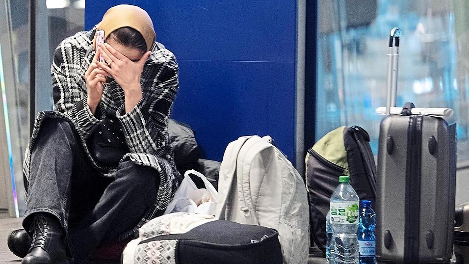 Eine Frau aus der Ukraine sitzt nach ihrer Flucht aus dem ukrainischen Kriegsgebiet im Hauptbahnhof auf dem Boden und telefoniert.
