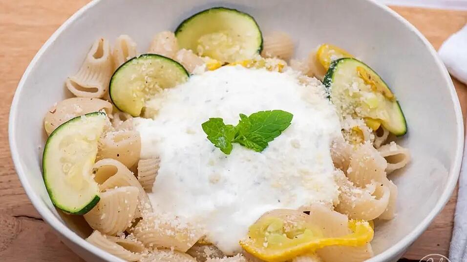 Die feine Zucchinipasta wird mit Minzjoghurt und Parmesan serviert.