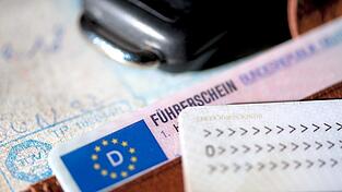 Ein F&uuml;hrerschein, ein Autoschl&uuml;ssel, ein Personalausweis und eine Zulassungsbescheinigung liegen auf einem Portemonnaie. Aktuell &auml;chzt die F&uuml;hrerscheinstelle unter dem Ansturm von B&uuml;rgern, die knapp vor Ablauf der Frist ihren F&uuml;hrerschein gegen die aktuelle Version tauschen wollen. Es kommt zu Engp&auml;ssen, die die Betroffenen ver&auml;rgern.