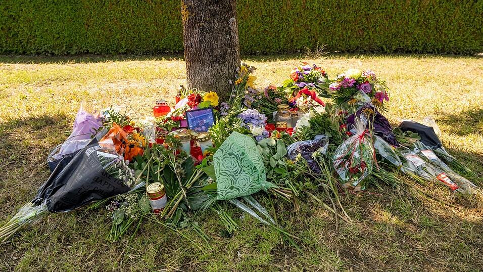 Blumen, Kerzen und Bilder liegen an einem Baum, in dessen Nähe am 17. August eine weibliche Leiche in einem Auto entdeckt wurde.