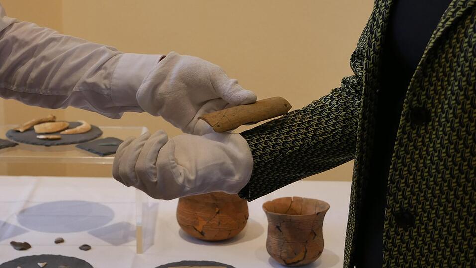 Die Armschiene schützte Bogenschützen vor der zurückschnellenden Pfeilsehne, sagt Archäologe Christoph Steinmann vom Landesamt für Denkmalpflege und demonstriet am Arm der Regensburger Landrätin Tanja Schweiger (FW), wo die Schiene saß. Die Armschiene schützte Bogenschützen vor der zurückschnellenden Pfeilsehne, sagt Archäologe Christoph Steinmann vom Landesamt für Denkmalpflege und demonstriet am Arm der Regensburger Landrätin Tanja Schweiger (FW), wo die Schiene saß.