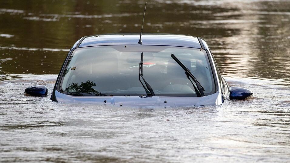 Ein Auto steht auf einem Parkplatz im Hochwasser, nachdem die Aisch &uuml;ber die Ufer getreten war.