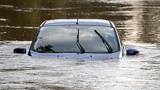 Ein Auto steht auf einem Parkplatz im Hochwasser, nachdem die Aisch über die Ufer getreten war. Ein Auto steht auf einem Parkplatz im Hochwasser, nachdem die Aisch über die Ufer getreten war.