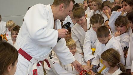 Große Augen, glänzende Medaille: Die Kinder durften die echte Olympiamedaille von Peking 2008 sogar anfassen.