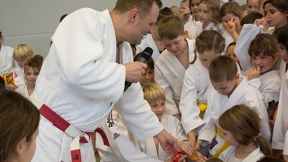 Große Augen, glänzende Medaille: Die Kinder durften die echte Olympiamedaille von Peking 2008 sogar anfassen.