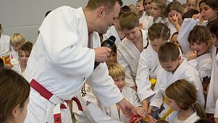 Große Augen, glänzende Medaille: Die Kinder durften die echte Olympiamedaille von Peking 2008 sogar anfassen.