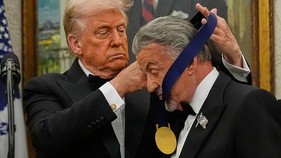 US-Präsident Donald Trump hängt der Actionfilm-Ikone Sylvester Stallone eine Medaille um. US-Präsident Donald Trump hängt der Actionfilm-Ikone Sylvester Stallone eine Medaille um.