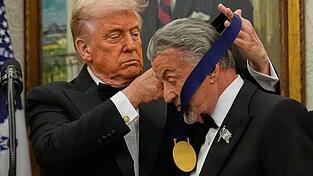 US-Präsident Donald Trump hängt der Actionfilm-Ikone Sylvester Stallone eine Medaille um. US-Präsident Donald Trump hängt der Actionfilm-Ikone Sylvester Stallone eine Medaille um.