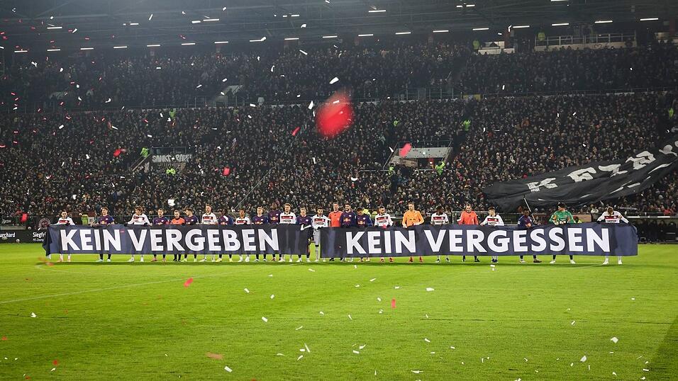 Spieler beider Teams halten vor Spielbeginn ein Banner anl&auml;sslich das Holocaust-Gedenktags hoch.