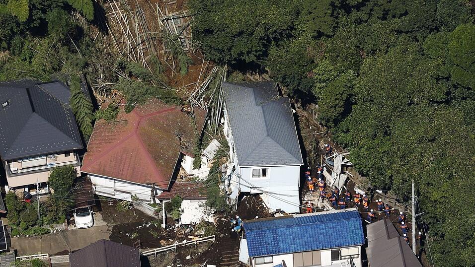 In Miura in der Präfektur Kanagawa im Osten Japans wurden Häuser teilweise von einer Schlammlawine verschüttet. In Miura in der Präfektur Kanagawa im Osten Japans wurden Häuser teilweise von einer Schlammlawine verschüttet.