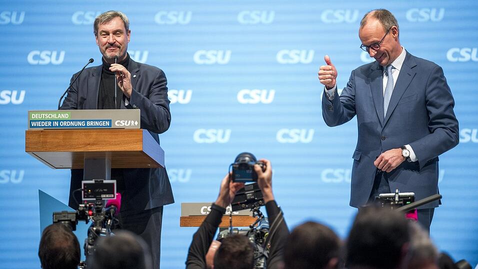 Markus S&ouml;der (l.) begr&uuml;&szlig;t Friedrich Merz (r.), Kanzlerkandidat und Vorsitzender der CDU/CSU Bundestagsfraktion, beim kleinen CSU-Parteitag auf der B&uuml;hne.