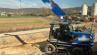 Der besch&auml;digte Bagger steht an einer Baustelle neben den Bahngleisen.