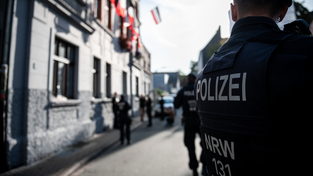 Polizei steht vor einem Haus im Stadtteil Dorstfeld, bei dem Reichsflaggen aus dem Fenster hängen. Unter dem Schutz der Polizei haben Graffitikünstler Nazi-Schmierereien übersprüht. Mit der Aktion am Freitagmorgen wollten Stadt, Polizei und engagierte Bürger ein Zeichen gegen rechte Hetze und Rechtsextremismus setzen. Polizei steht vor einem Haus im Stadtteil Dorstfeld, bei dem Reichsflaggen aus dem Fenster hängen. Unter dem Schutz der Polizei haben Graffitikünstler Nazi-Schmierereien übersprüht. Mit der Aktion am Freitagmorgen wollten Stadt, Polizei und engagierte Bürger ein Zeichen gegen rechte Hetze und Rechtsextremismus setzen.