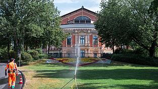 Ein städtischer Mitarbeiter bewässert die Grünfläche vor dem Festspielhaus. Ein städtischer Mitarbeiter bewässert die Grünfläche vor dem Festspielhaus.
