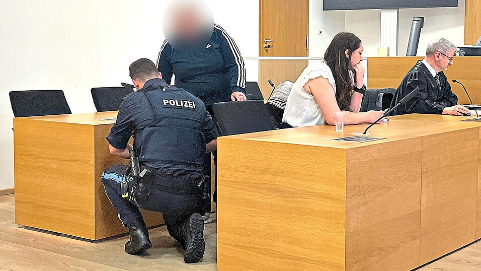 Der Angeklagten werden von einem Beamten die Fu&szlig;fesseln abgenommen. Mit auf dem Bild ihre &Uuml;bersetzerin und ihr Anwalt Stefan Rothneichner.