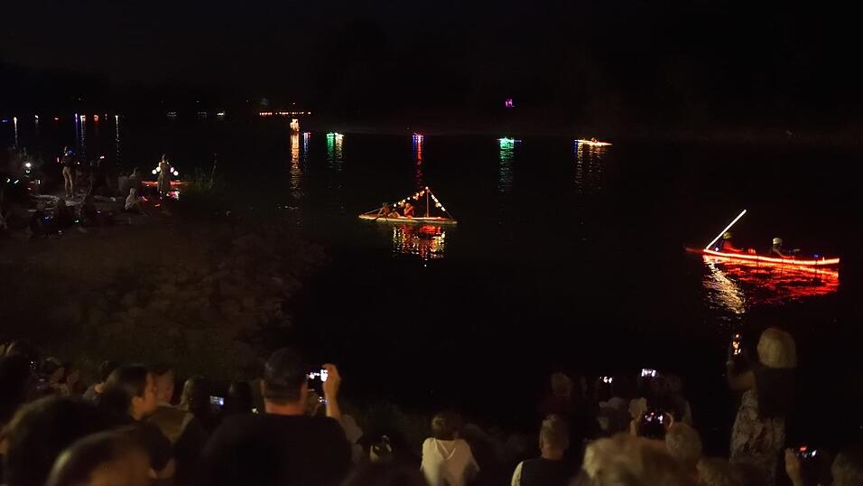 Bunt beleuchtete Boote fahren bei der Lampionfahrt über die Donau.