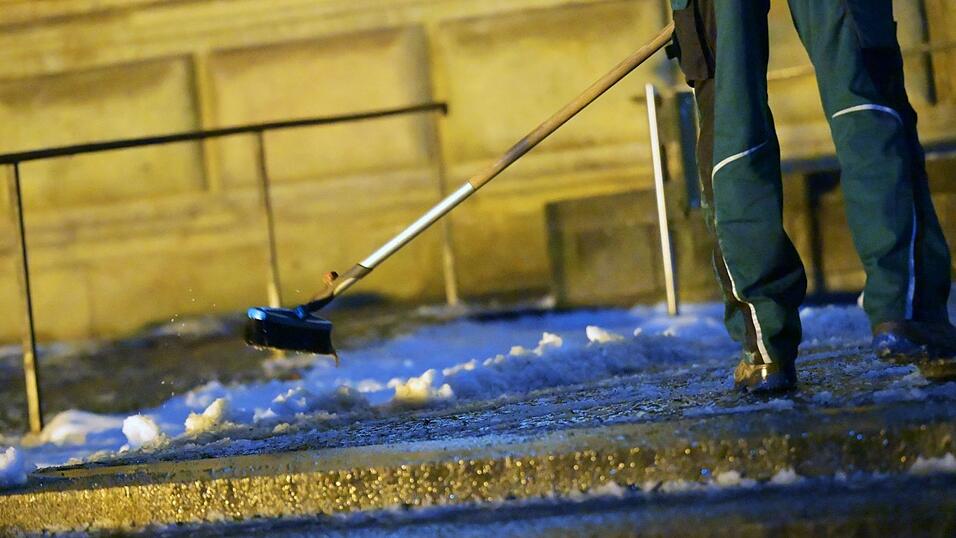 Ein Mann r&auml;umt Schnee vor der Alten Pinakothek in M&uuml;nchen. In der Nacht soll es wieder k&auml;lter werden, mit Schneefall bis in die Niederungen.