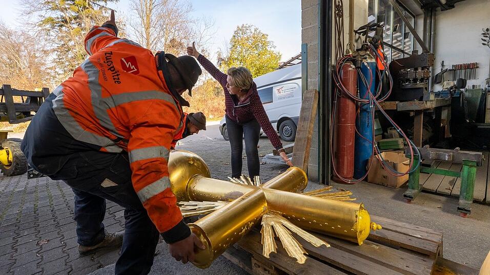 Kunstschmiedin Andrea Würzinger soll die dicke Schicht Aufkleber entfernen, den Untergrund schleifen sowie Lack und neues Blattgold aufbringen.